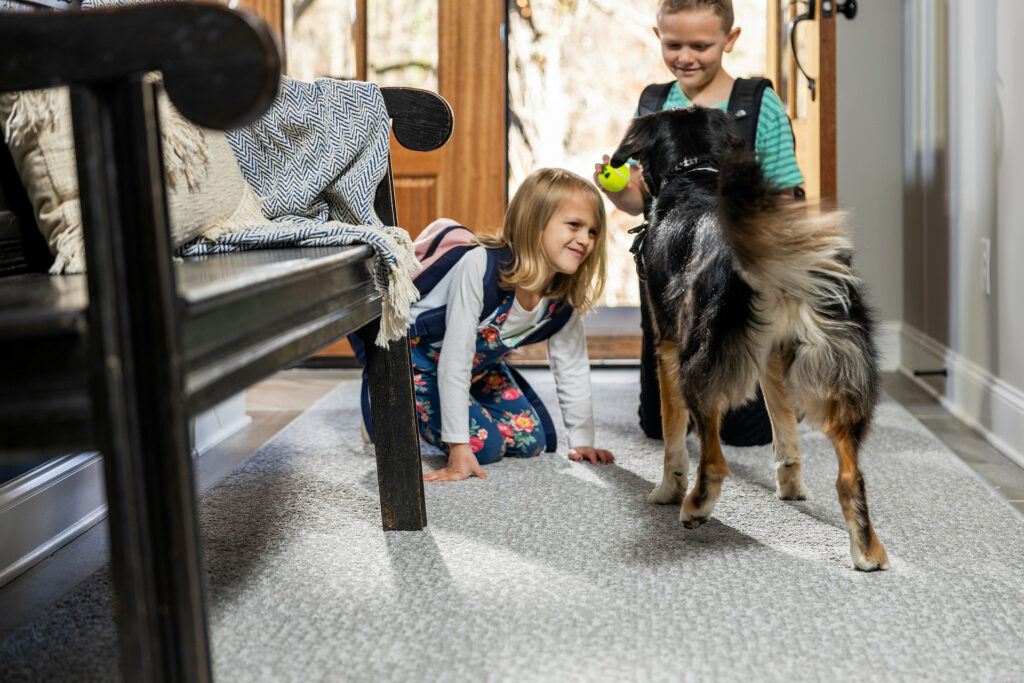 Kids playing with dog on carpet floors | Corvin's Furniture & Flooring